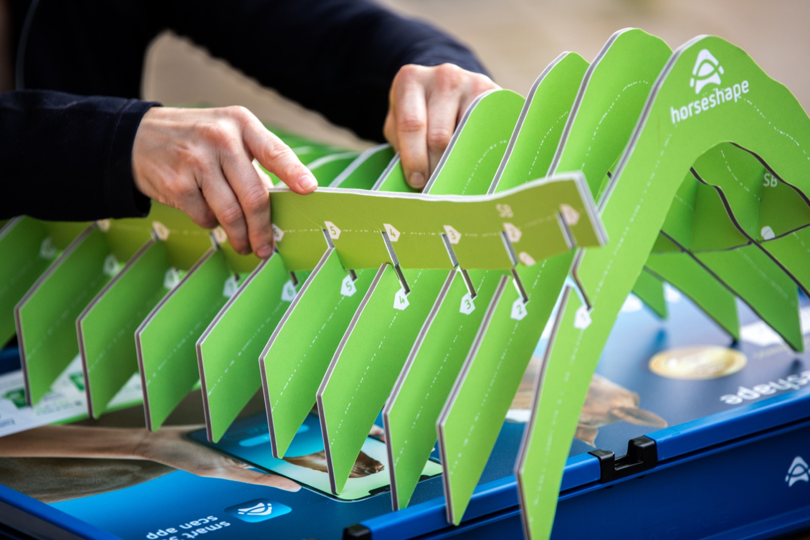 Hands unfolding a physical FittingSet template in the workshop
